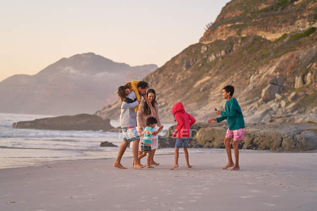 Famiglia che gioca sulla spiaggia dell'oceano — Foto stock