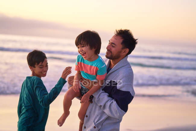 Feliz pai e filhos brincando na praia do oceano — Fotografia de Stock