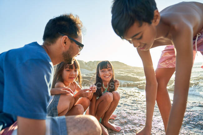 Famille heureuse dehors dans la plage ensoleillée — Photo de stock