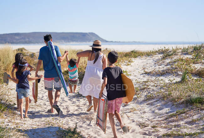 Familia feliz afuera en la playa soleada - foto de stock