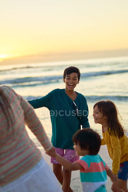 Familia feliz afuera en la playa soleada - foto de stock