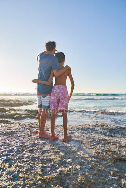 Liebevoller Vater und Sohn am sonnigen Ozeanstrand — Stockfoto