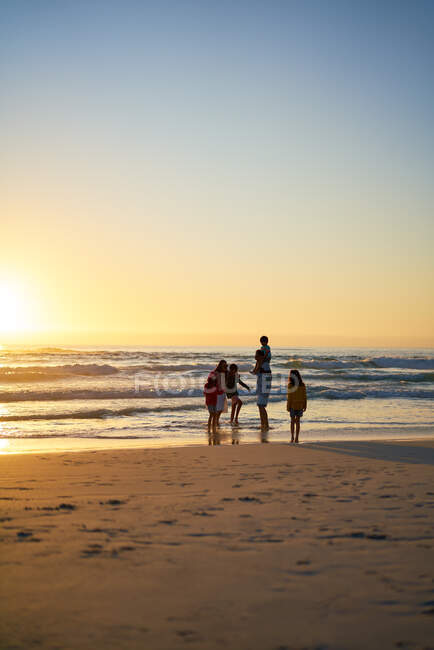 Família vadear no oceano surfar na praia ao pôr do sol — Fotografia de Stock