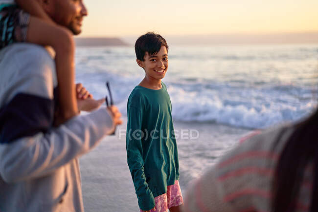 Portrait happy boy on ocean beach with family — Stock Photo