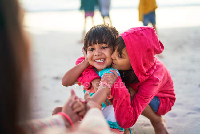 Affectionate brother and sister on beach — Stock Photo