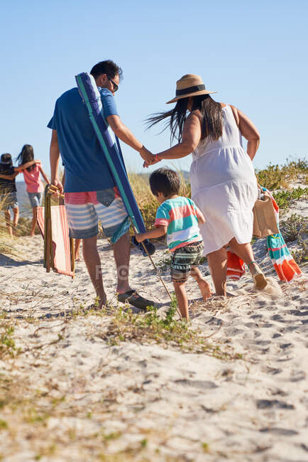 Promenade en famille dans le sable sur une plage ensoleillée — Photo de stock