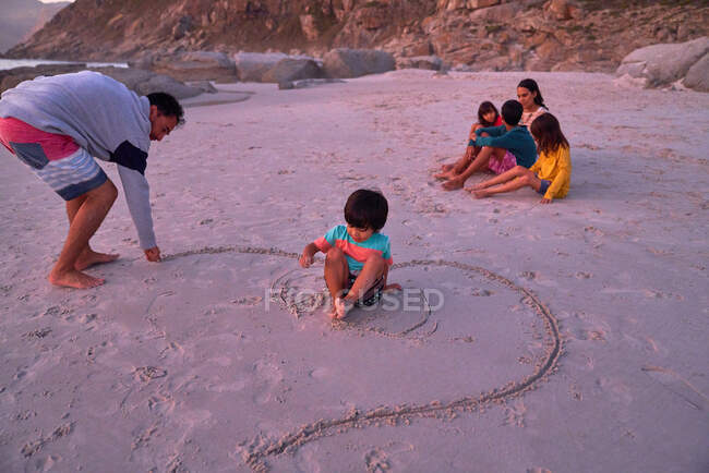 Disegno di famiglia in sabbia sulla spiaggia — Foto stock