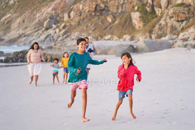 Joyeux famille courir sur la plage — Photo de stock