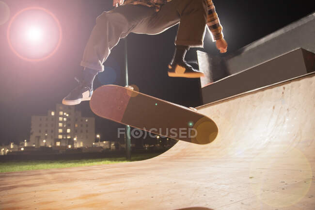 Молодой человек катается на скейтборде на рампе в скейт-парке — стоковое фото