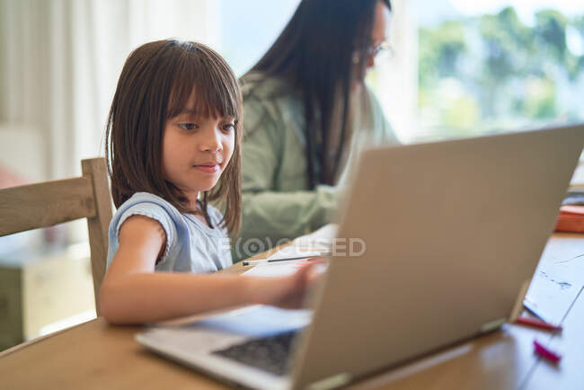 Девочка на домашнем обучении за ноутбуком — стоковое фото