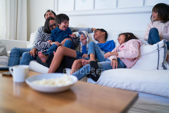 Игровая семья на диване в гостиной — стоковое фото