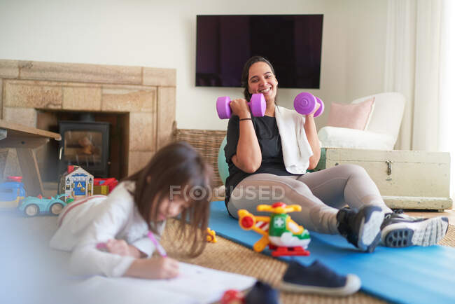 Mãe feliz exercitando e assistindo filha desenho — Fotografia de Stock