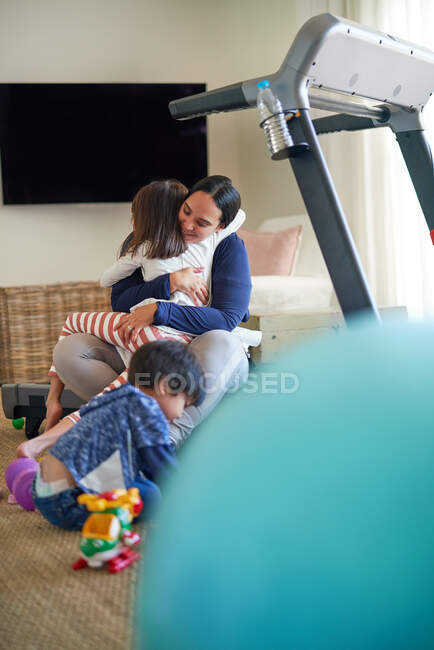 Affectueuse mère et fille câlins dans le salon — Photo de stock