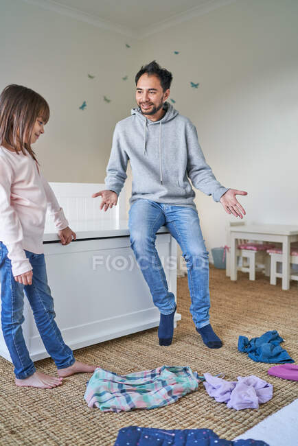 Батько допомагає дочці чистої спальні — стокове фото