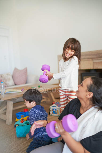 Happy mother and daughter exercising with dumbbells — Stock Photo