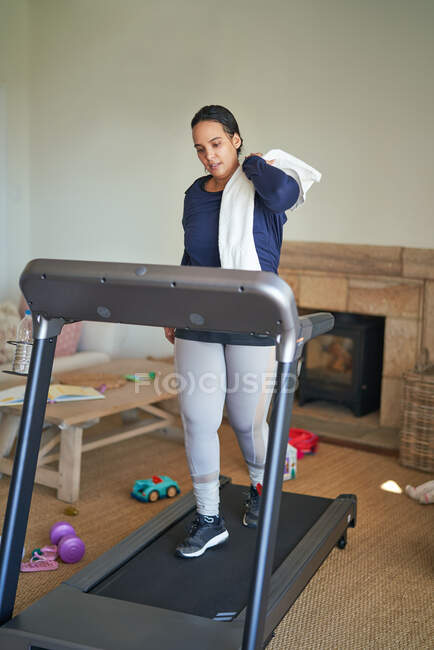 Mulher se exercitando na esteira na sala de estar — Fotografia de Stock