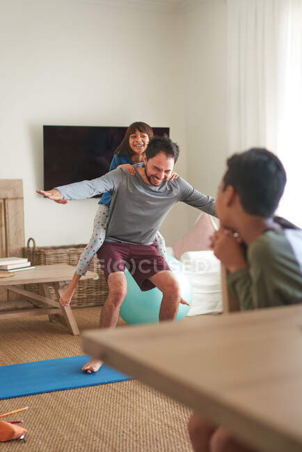 Père et fille ludiques faisant de l'exercice dans le salon — Photo de stock