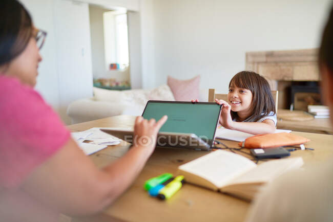Дочь отвлекает мать, работающую за ноутбуком — стоковое фото