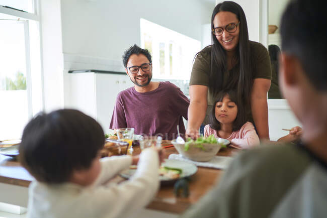 Счастливая семья обедает за столом — стоковое фото