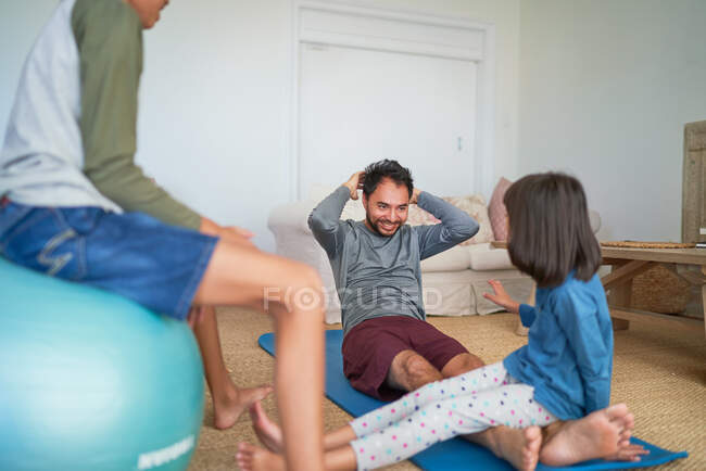 Vater und Kinder üben im Wohnzimmer — Stockfoto