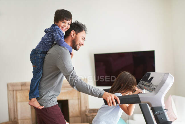 Playful kids on treadmill with father — Stock Photo