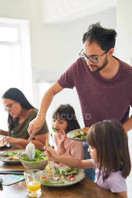 Familie isst Salat-Mittagessen am Tisch — Stockfoto