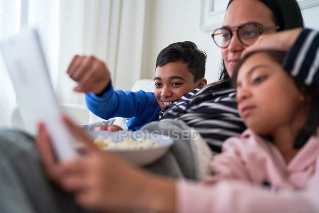 Mãe e crianças com pipoca assistindo filme no tablet digital — Fotografia de Stock