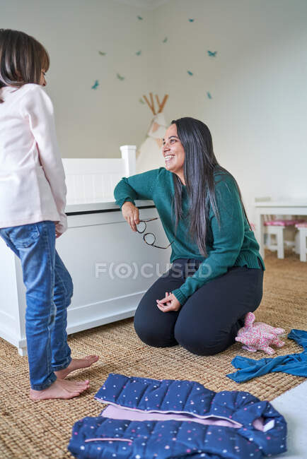 Mãe e filha feliz fazendo lavanderia no quarto — Fotografia de Stock