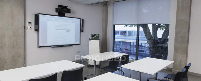 Sala de aula vazia com tela de projeção — Fotografia de Stock