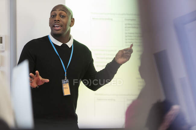 Преподаватель мужского пола, ведущий урок на проекционном экране в классе — стоковое фото