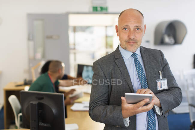 Портрет впевненого чоловіка-адміністратора з цифровим планшетом у клініці — стокове фото