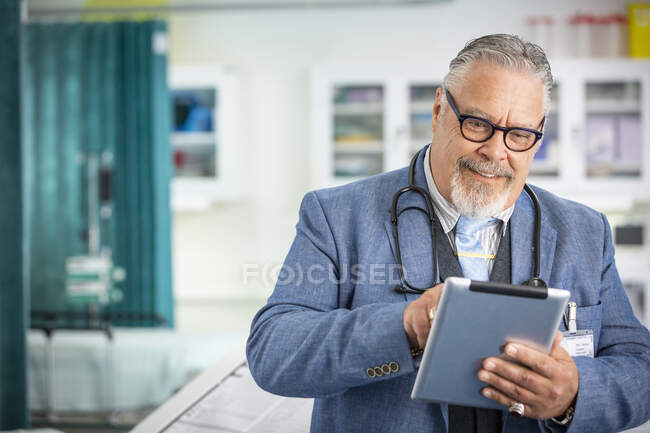 Médecin masculin utilisant une tablette numérique en clinique — Photo de stock