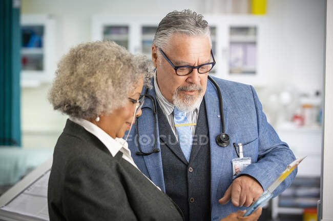 Médecins seniors utilisant une tablette numérique à l'hôpital — Photo de stock
