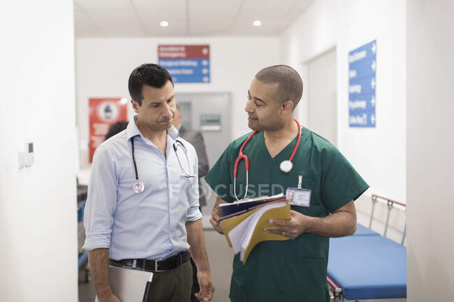 Médico y cirujano haciendo rondas en el pasillo del hospital - foto de stock