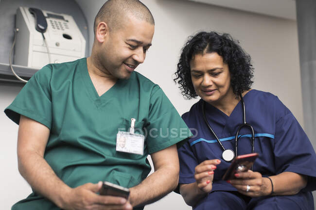 Médico y cirujano usando teléfonos inteligentes - foto de stock
