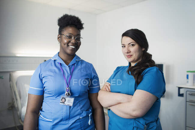 Enfermera y doctora confiada en retratos en la habitación del hospital - foto de stock