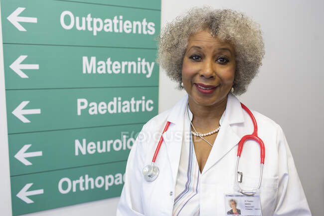 Retrato confiante médico sênior feminino no corredor do hospital — Fotografia de Stock