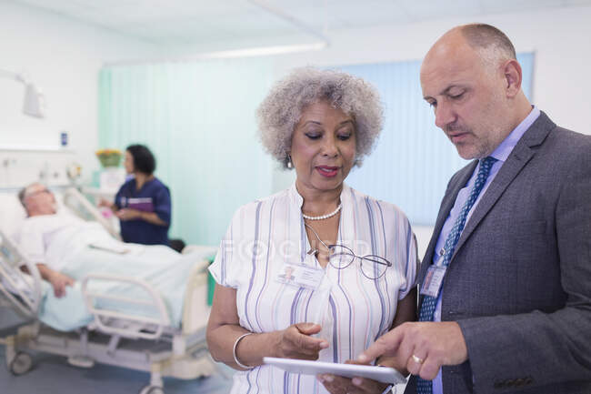 Médecins avec tablette numérique faisant des rondes, consultation dans la chambre d'hôpital — Photo de stock