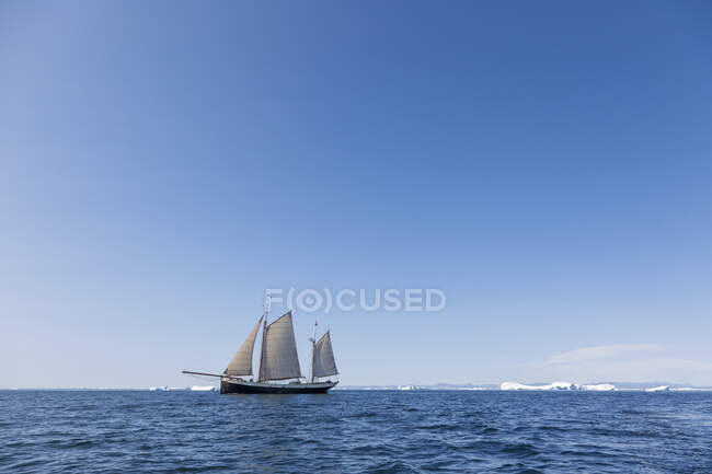 Nave che naviga oltre lo scioglimento del ghiaccio polare sulla soleggiata Groenlandia blu dell'Oceano Atlantico — Foto stock
