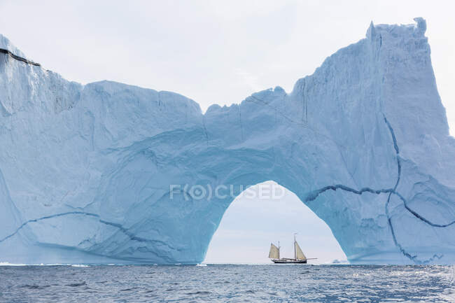 Ship sailing behind majestic iceberg formation on Atlantic Ocean Greenland — Stock Photo