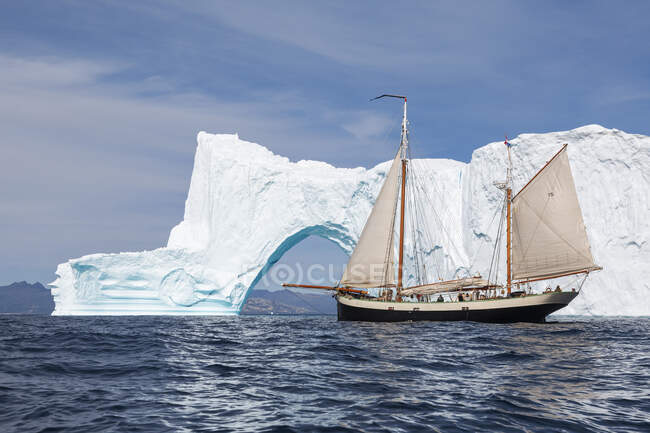 Ship moving toward iceberg arch on sunny Atlantic Ocean Greenland — Stock Photo