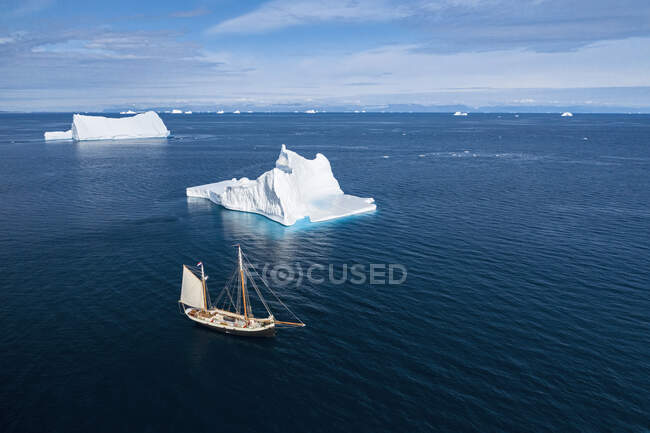 Ship sailing past majestic icebergs on sunny blue Atlantic Ocean Greenland — Stock Photo