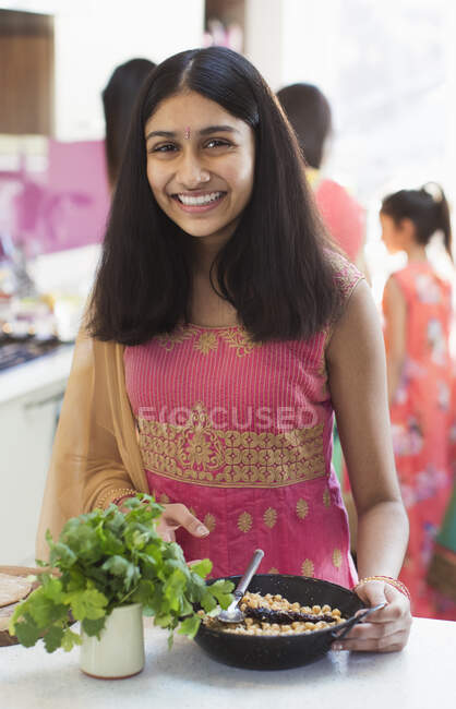 Портрет улыбающейся индийской девушки в сари, кушающей на кухне — стоковое фото