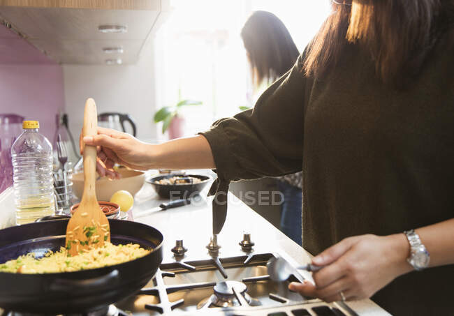 Frau kocht Reis auf Herd in Küche — Stockfoto