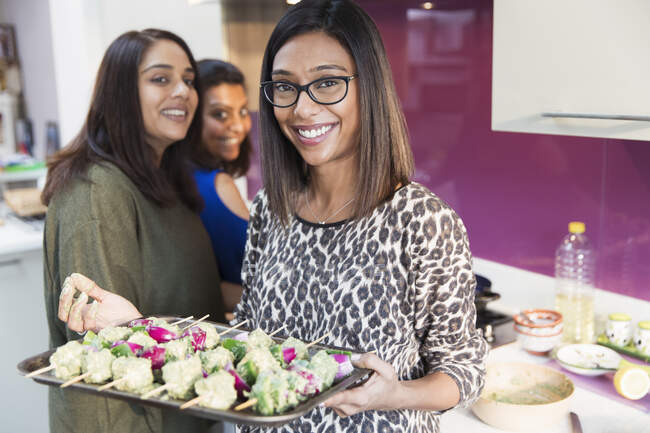 Portrait happy Indian woman with tray of kebabs — Stock Photo