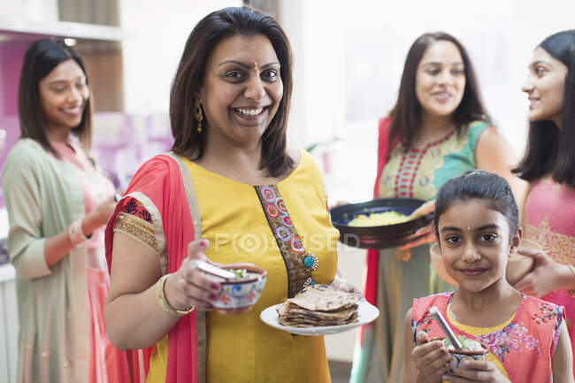 Portrait happy mother and daughter in Indian saris with food — Stock Photo