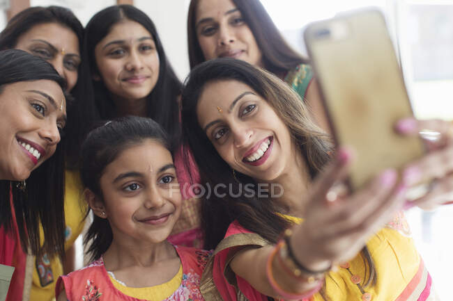 Mujeres y niñas indias felices en saris tomando selfie - foto de stock