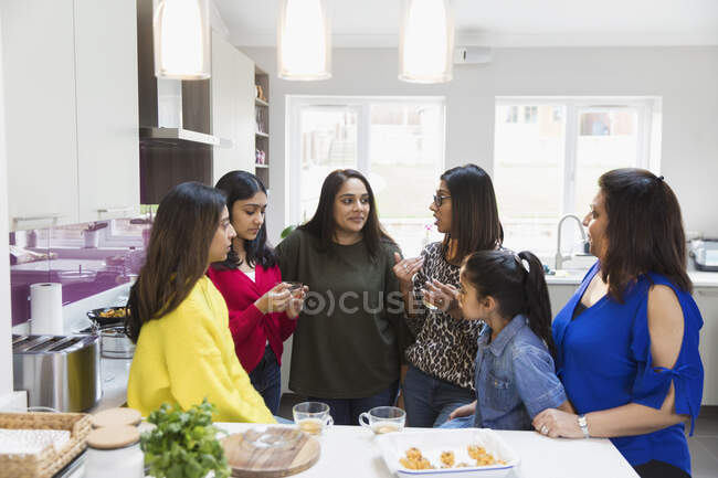 Indian women talking and cooking in kitchen — Stock Photo