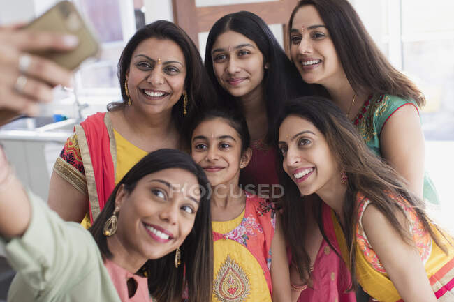 Mujeres y niñas indias felices en saris tomando selfie - foto de stock