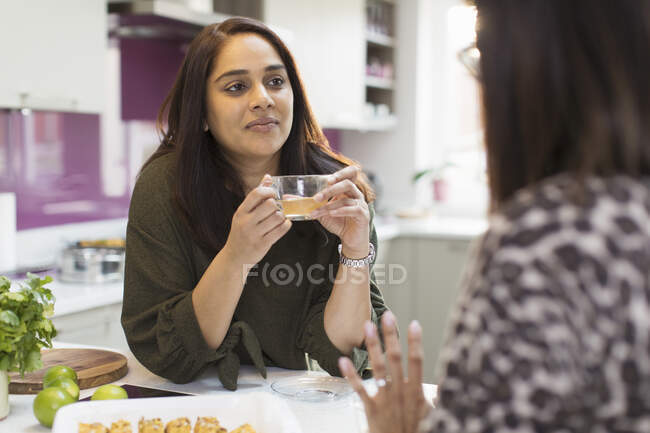 Женщины разговаривают и пьют чай на кухне — стоковое фото